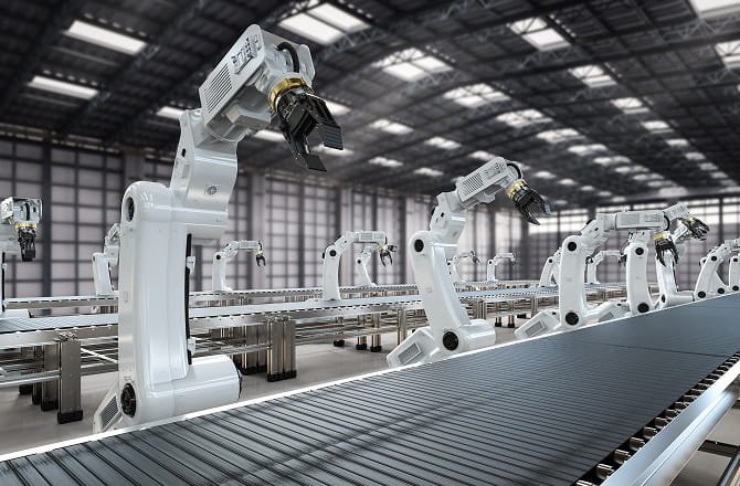 Robotic arms alongside an industrial conveyor